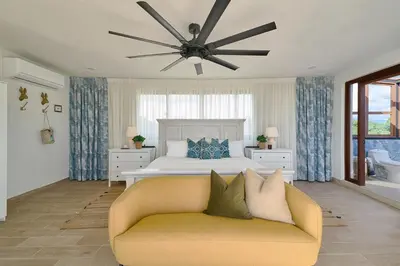 a bedroom with a bed and a couch and a ceiling fan at Villa La Chiquita Paradise Pool and BBQ in Baní
