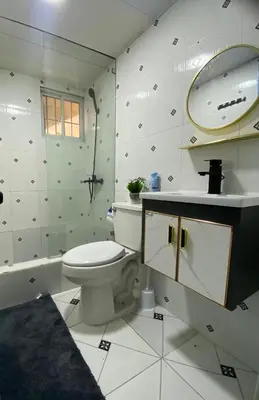 a bathroom with a toilet and a sink and a mirror at Modern, Unique And Stylish 1 Bedroom Apartment in San Pedro de Macorís