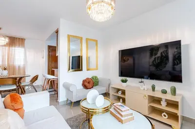 a living room with a large flat screen tv at Chic Urban Retreat with Pool, Gym, & Free Parking in Santiago de los Caballeros