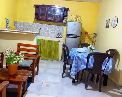 a kitchen with a table and chairs and a refrigerator at Rincón del Mojito in Santa Cruz de Barahona