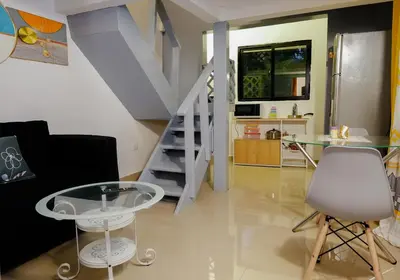 a living room with a glass table and a staircase at Casa Ballenas2 in Las Terrenas