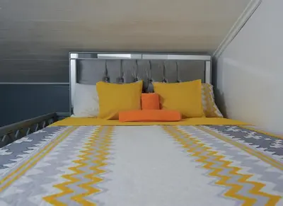 a bed with yellow and orange pillows on it at Casa Ballenas2 in Las Terrenas