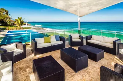 a patio with couches and a view of the ocean at Bluegreen Oceanfront Condo at Laguna Beach in Sosúa