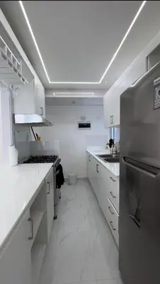 a kitchen with white cabinets and a stainless steel refrigerator at Santo Domingo Este Stylish Condo in San Isidro