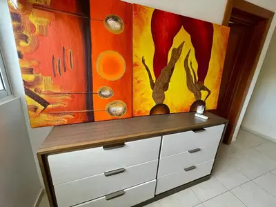 a dresser in a room with a painting on the wall at Spacious apartment beach access in Juan Dolio