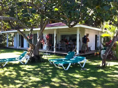 two lawn chairs sitting in the grass in front of a house at Villa Bianca - BEACHFRONT with Pool in Sosúa
