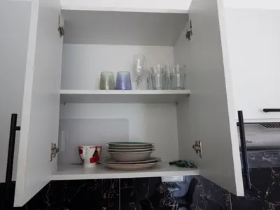 a pantry with plates and glasses on shelves at APE Dream Villa in Itabo