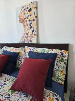a bed with pillows and a painting on the wall at Casa CASTILLO in La Laguna