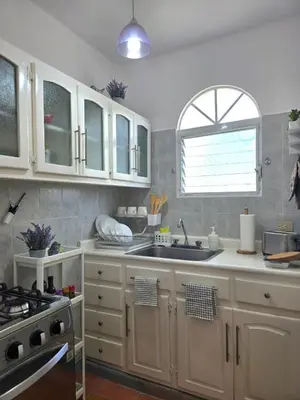 a kitchen with white cabinets and a sink and a window at Casa CASTILLO in La Laguna