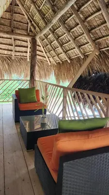 a room with couches and tables in a straw roof at Boho villas and spa in El Valle