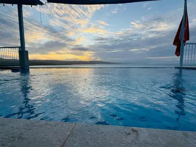 a pool of water with a sunset in the background at Sundown Relaxed in Punta Rucia