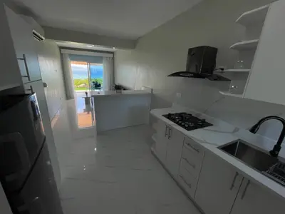 a white kitchen with a sink and a stove at Sundown Relaxed in Punta Rucia