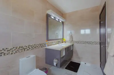 a bathroom with a sink and a toilet and a mirror at Beautiful villa in the Caribbean! in Sosúa