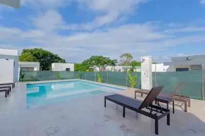 a swimming pool with two lounge chairs and a table at Beautiful villa in the Caribbean! in Sosúa