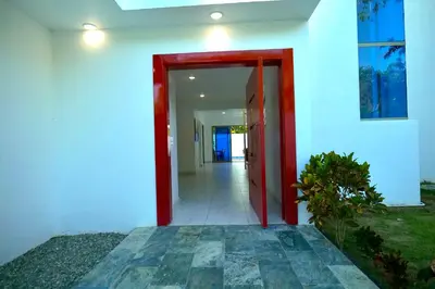 a red door leading into a white building at Villa Pravda Paradise Guerra in La Caoba