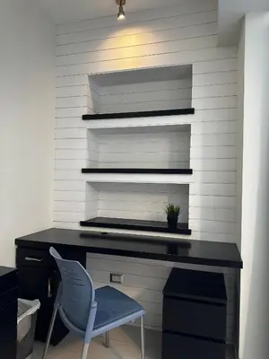 a desk with a blue chair in front of a wall at Armonia 17 suites by Yellowkey in Santo Domingo