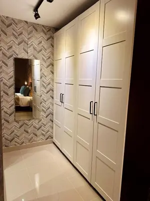 a room with white lockers and a bedroom at Acogedor Penthouse de 2 habitación in Santiago de los Caballeros