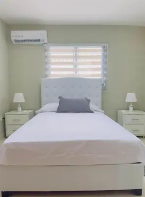a bedroom with a large white bed with two night stands at Excelente Apartamento Completo Renta Carro Disponible in La Viva