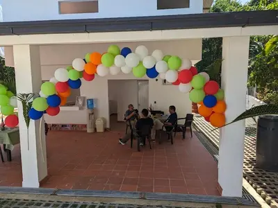 a group of people sitting at a table under a bunch of balloons at Spacious Apartment w Pool in Las Terrenas