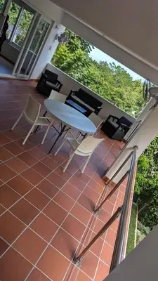 a patio with a table and chairs on a balcony at Spacious Apartment w Pool in Las Terrenas
