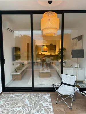 a room with a chair and a dining room at Cocotal 2beds apartament Golf Course Melia Beach PC RD in Punta Cana