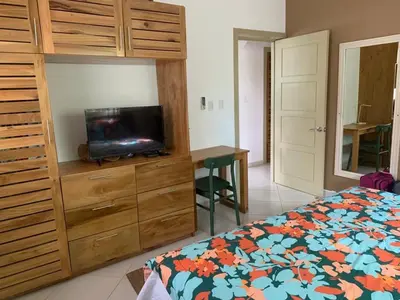 a bedroom with a bed and a dresser with a television at Gorgeous apartment steps to Playa Punta Popy in Las Terrenas