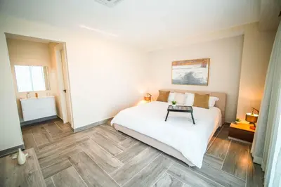 a bedroom with a white bed with a table on it at Aston Rubi City Suites in Santo Domingo