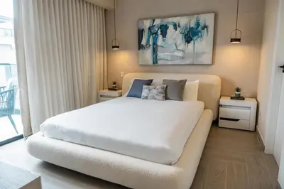 a bedroom with a white bed and a couch at Aston Rubi City Suites in Santo Domingo