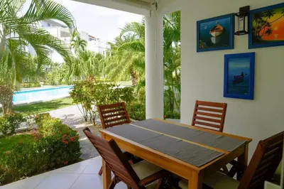 a dining room with a table and chairs and a pool at Gorgeous apartment steps to Playa Punta Popy in Las Terrenas