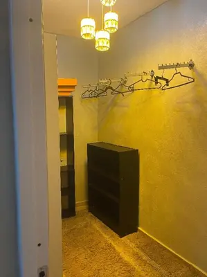a room with a yellow wall with a television and lights at Villa Tulum in San Cristóbal