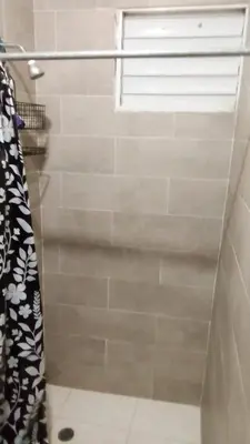 a bathroom with a shower with a window at Chez Guela in Mandinga