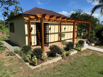 a small building with a pergola in a yard at Rancho Don Pedro in Bonao