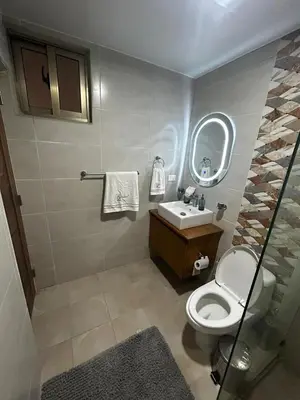 a bathroom with a toilet and a sink and a mirror at Tu guarida in Santo Domingo
