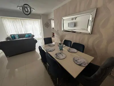 a dining room with a table and a couch at Tu guarida in Santo Domingo