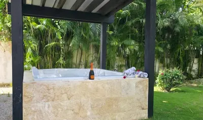a bath tub with a bottle of wine sitting on it at Aligio - A Quiet Retreat in Paradise - 2 BR, 2 pools, WiFi, AC, Private Hot Tub in Las Terrenas