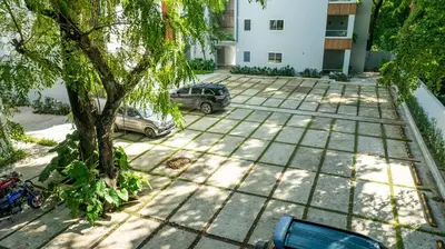 two cars parked in a parking lot with a tree at Perla Marina Beachside Apartment in Bombita