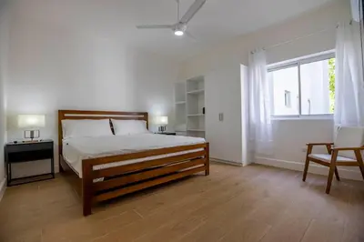 a bedroom with a bed and a large window at Perla Marina Beachside Apartment in Bombita