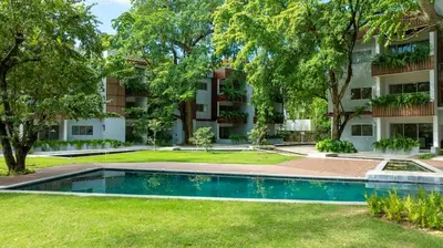 an apartment complex with a swimming pool in front of a building at Perla Marina Beachside Apartment in Bombita