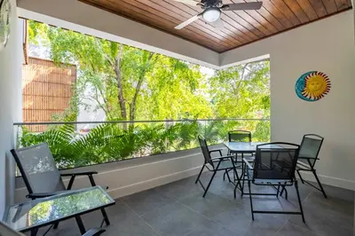 a patio with a table and chairs and a large window at Perla Marina Beachside Apartment in Bombita