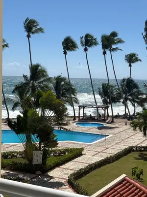 a view of the beach from the balcony of a resort at Albatros Cozy Apt in Juan Dolio
