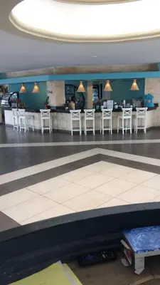 a lobby with a bar with white stools at Albatros Cozy Apt in Juan Dolio
