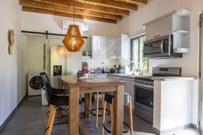 a kitchen with a wooden table and some chairs at ProCab Kaya Apartments Cabarete in Cabarete