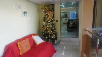 a christmas tree in a living room with a red couch at Aparta Hotel Ana Julia in Sosúa