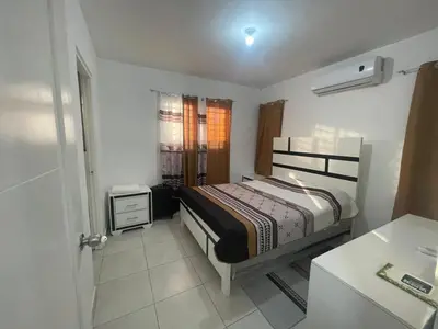 a bedroom with a bed and a table in it at Apartamento en Edificio Palmares in La Romana