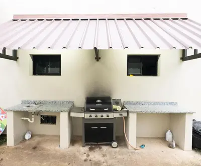 a barbecue outside of a house with awning at Blue Lux in Santiago de los Caballeros