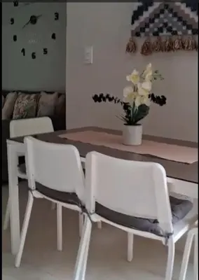 a dining room table and chairs with a vase of flowers at Flamingo Villa in Boca Paraiso in Boca Chica