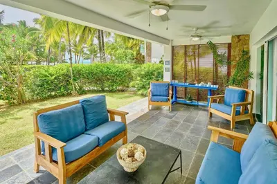 a living room with blue chairs and a table at Oceanfront Apt W- Private Beach - Las Terrenas in El Limón