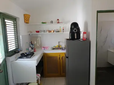 a small kitchen with a refrigerator and a sink at Cozy studio- centre - near beach in Las Terrenas