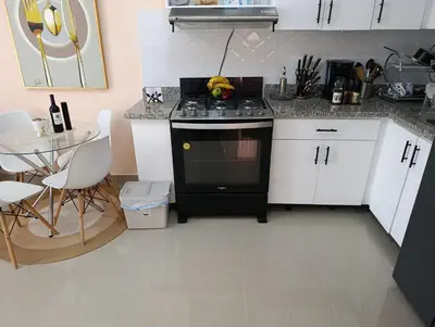a kitchen with a black stove and white cabinets at El descanso perfecto in El Cruce