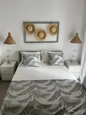 a bedroom with a large bed with two night stands at LA CASITA de Bayahibe in Bayahibe
